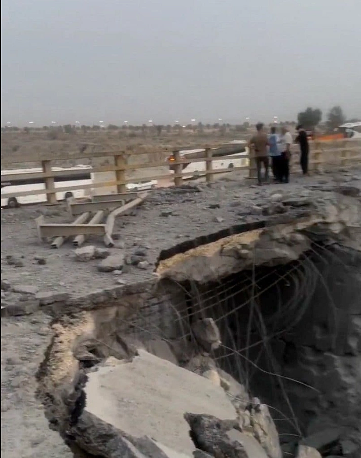Residents inspect the damage to a bridge destroyed in the missile strike in Bandar Khamir.